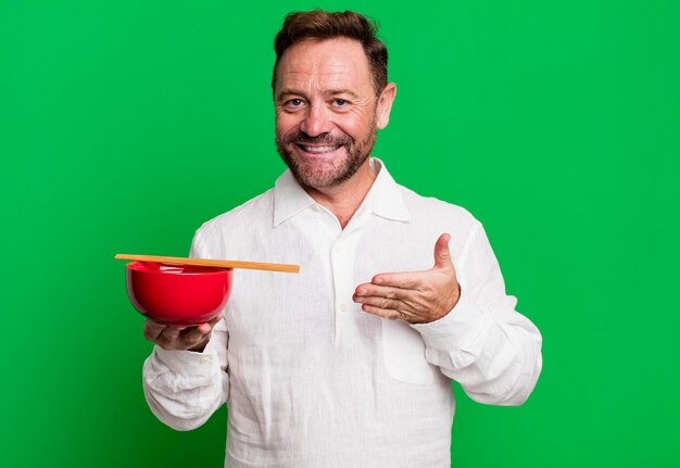 szczęśliwy kucharz prezentujący potrawę